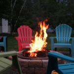 A firepit surrounded by summer chairs.