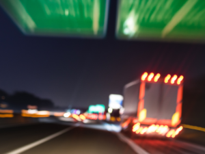 A POV of driving on the freeway at night. the lights of cars are blown out and blurry.
