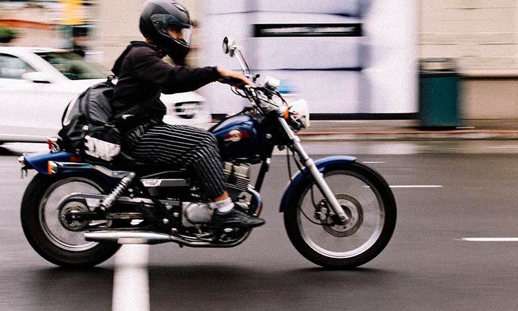 Blue motorcycle through city traffic