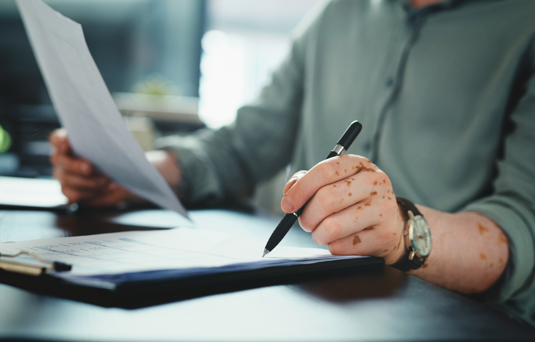 Shot of an unrecognizable businessman doing paperwork in an office at work